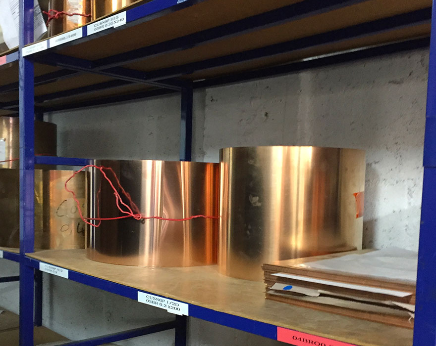 Rouleaux de laiton stockés en atelier avant transformation